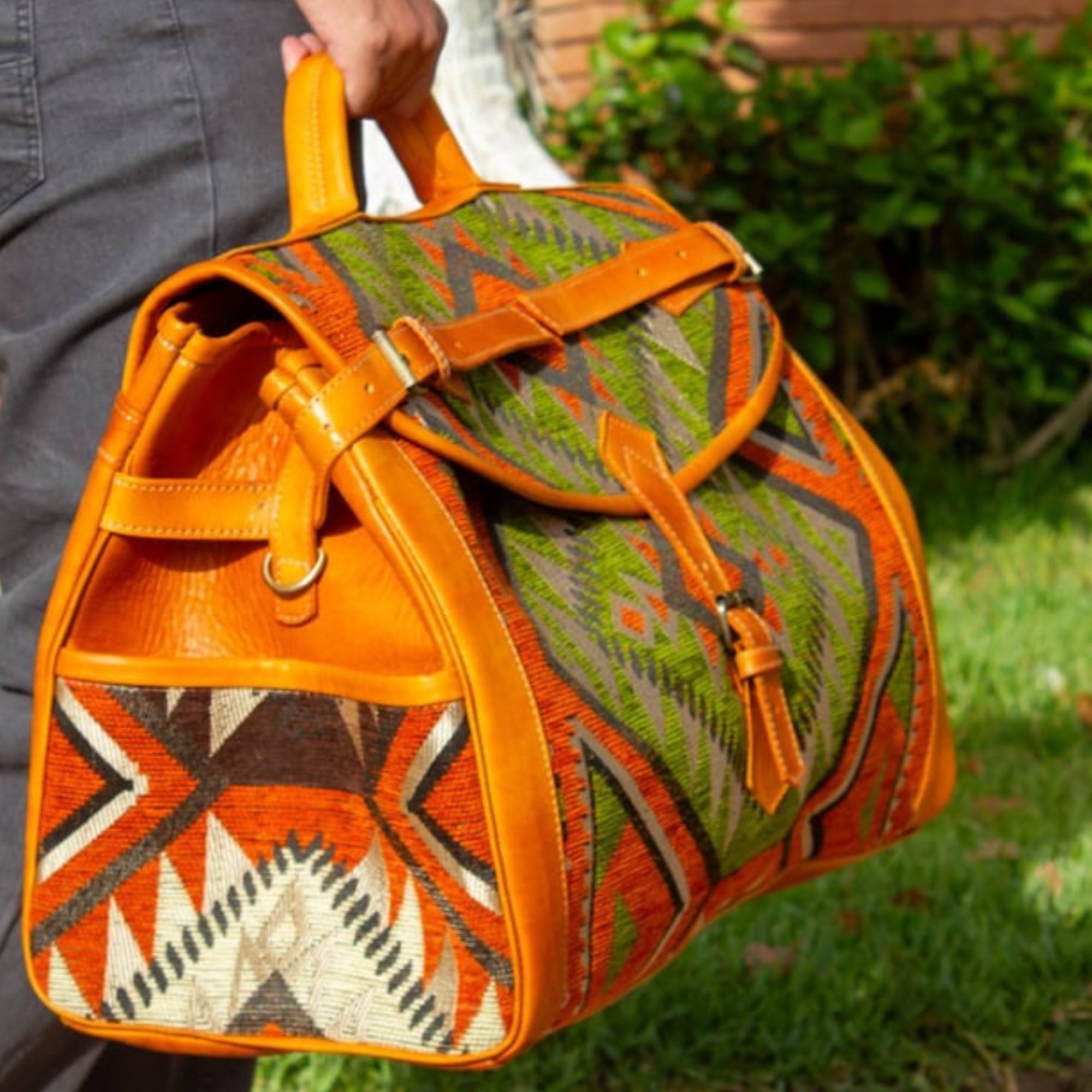 Person holding a patterned orange bag outdoors