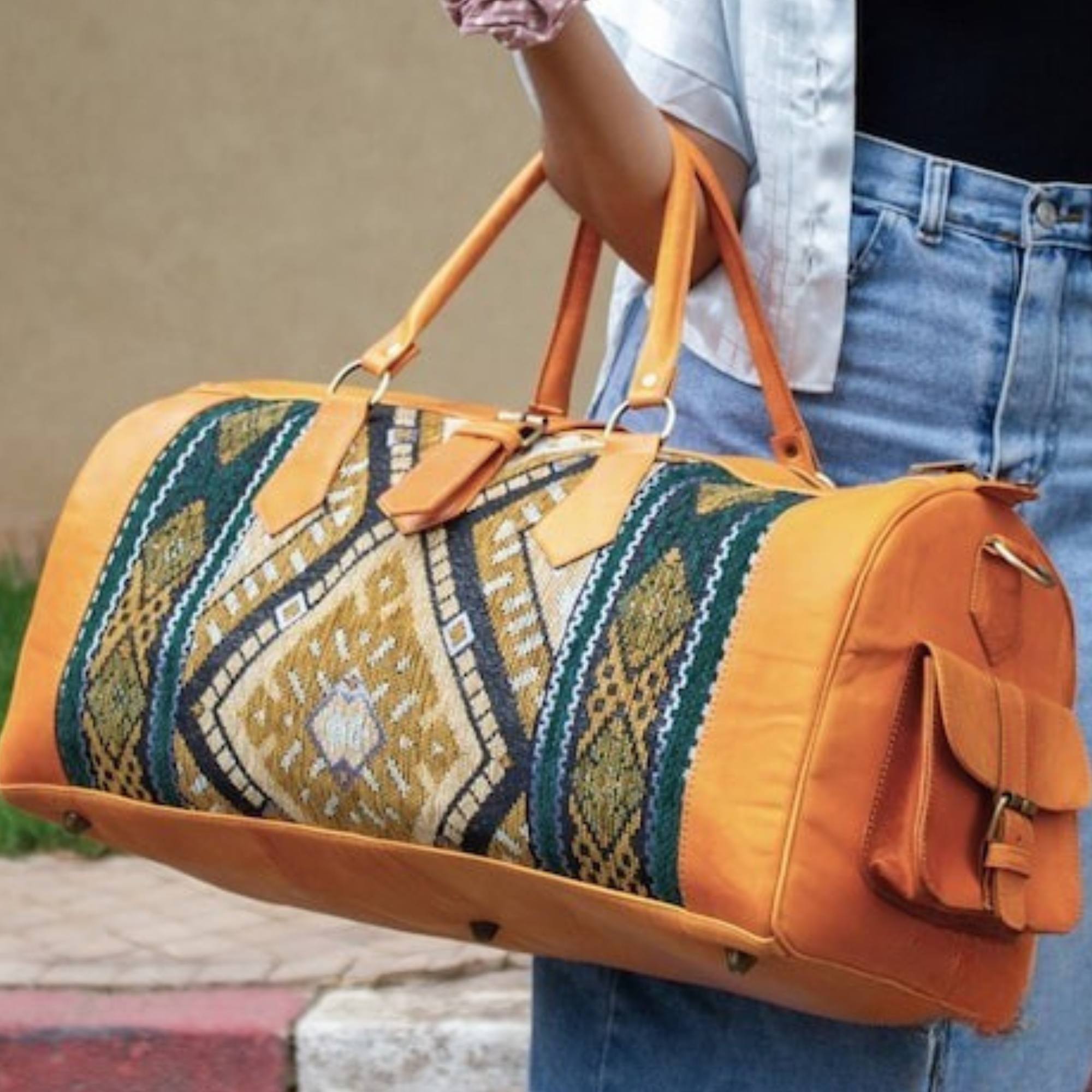 Person holding a patterned duffel bag with orange accents