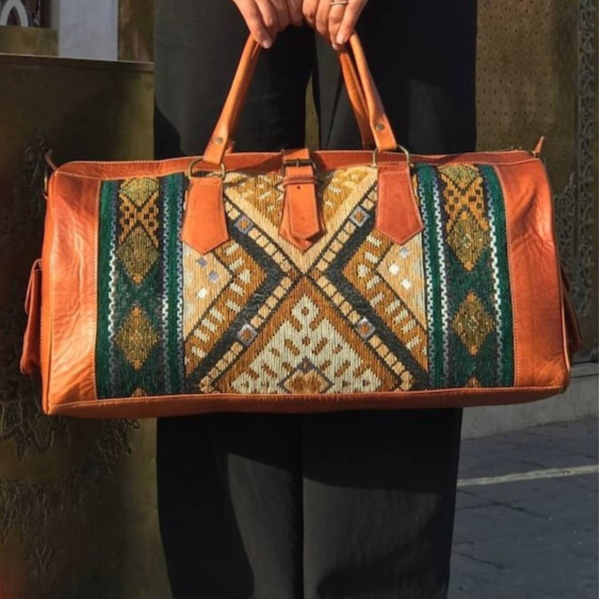Person holding a brown leather bag with geometric pattern