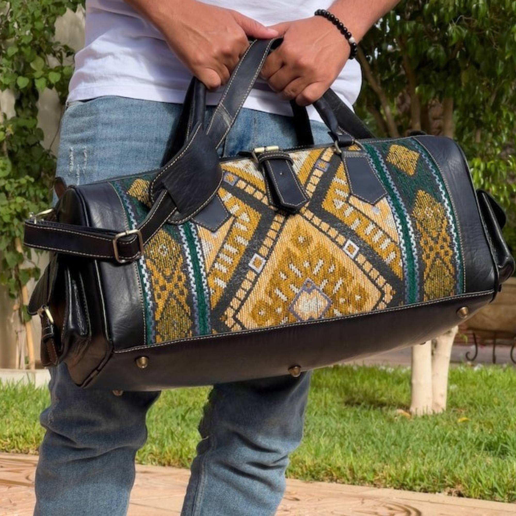 Person holding a patterned duffel bag outdoors
